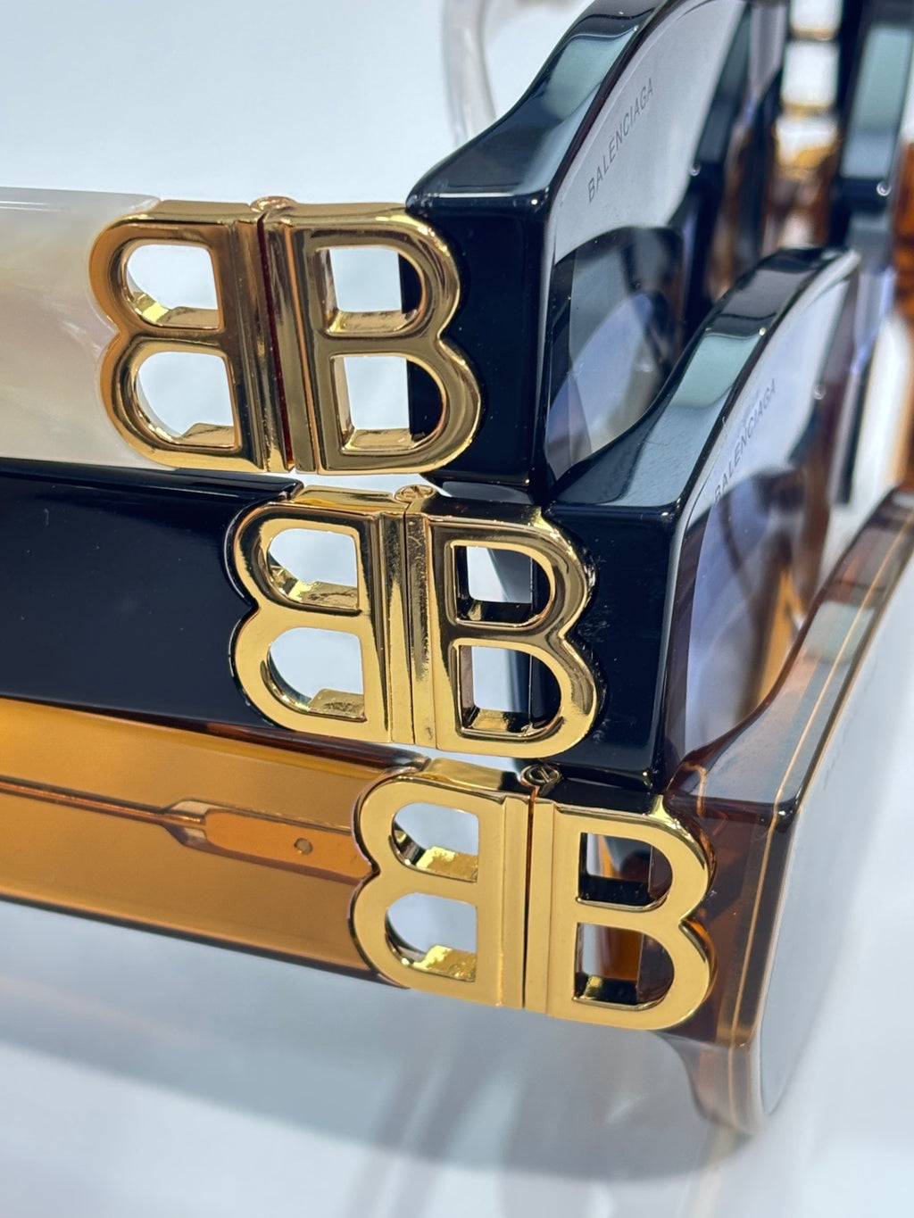 Gold B logo hardware on sunglasses frame with dark blue acetate