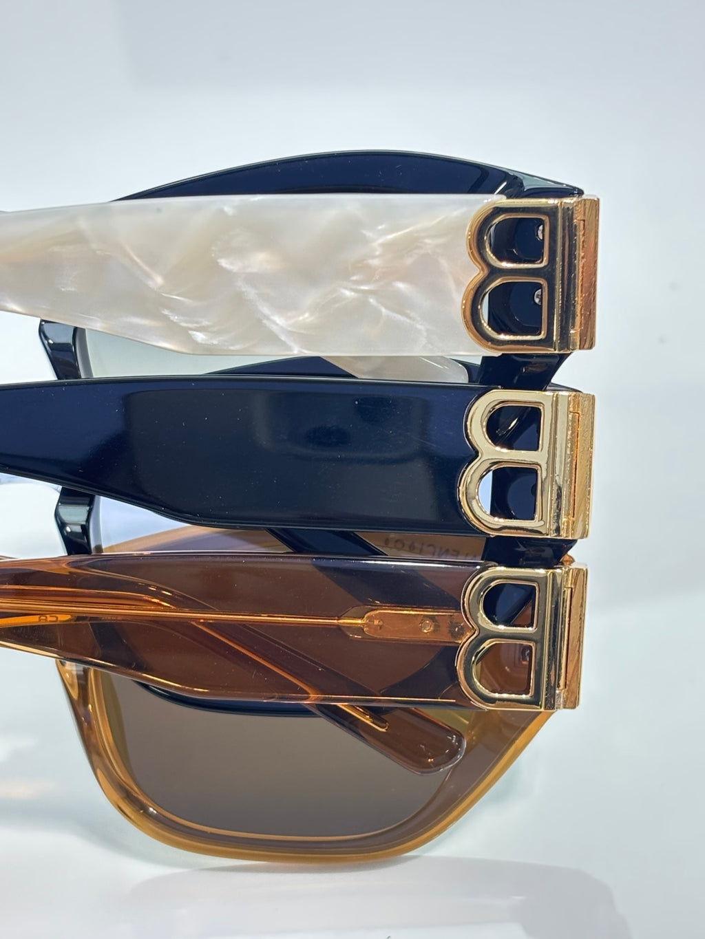 Sunglasses close-up with gold B emblem on temple and tinted lenses