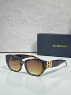 Sunglasses with tortoiseshell frames, amber lenses, and gold B emblem