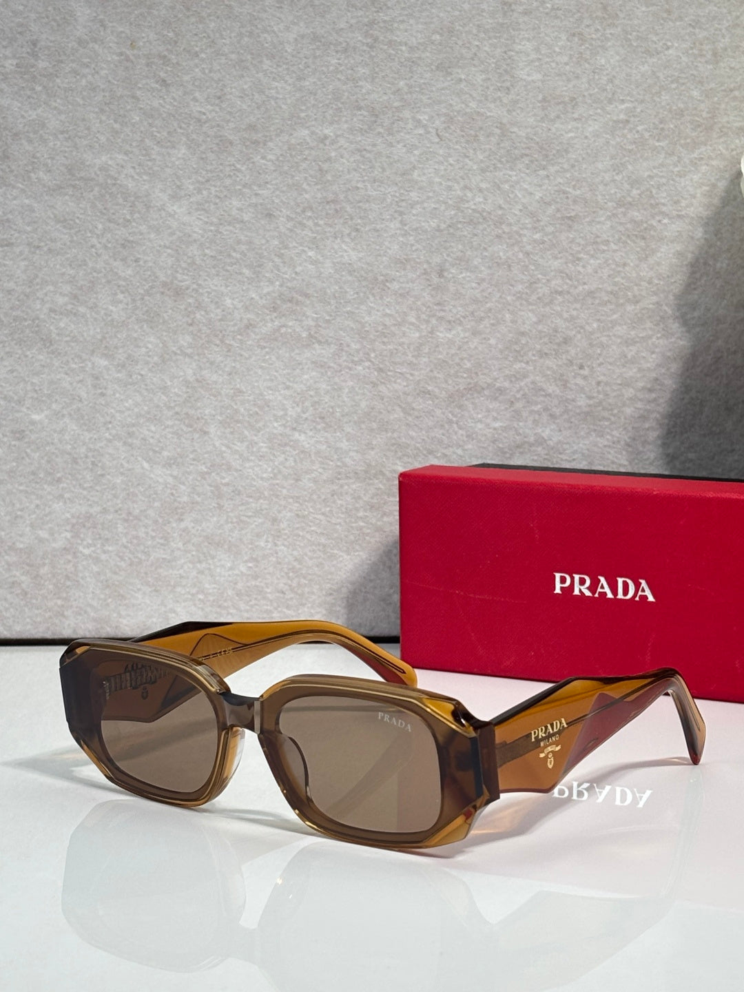 Prada sunglasses with brown and gold oversized frames and tinted lenses