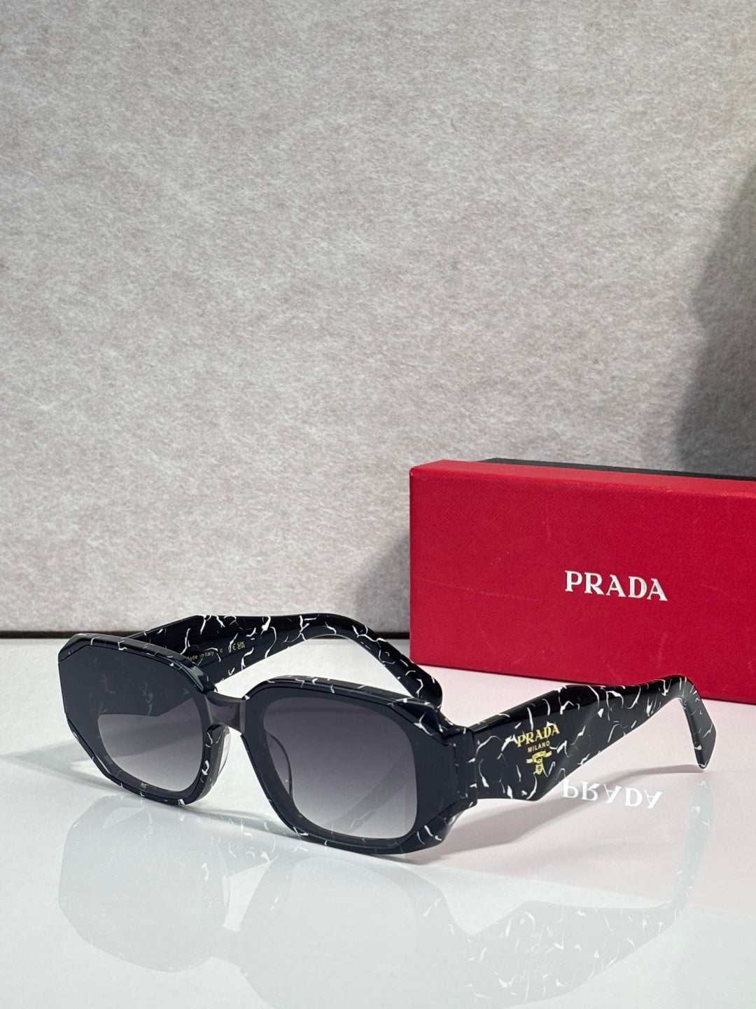 Prada sunglasses with dark navy oversized frames and tinted lenses