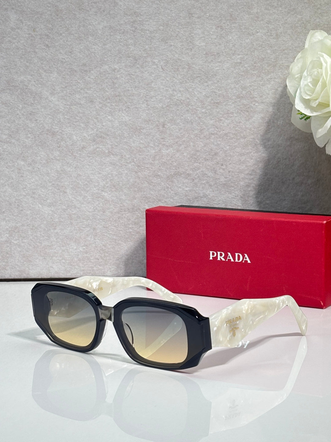 Prada sunglasses with dark navy oversized frames and tinted lenses