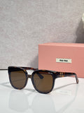 Sunglasses with dark acetate frames and brown-tinted lenses, with tortoiseshell temples
