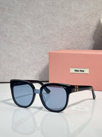 Sunglasses with dark frames and blue-tinted lenses, rounded shape with temple logo