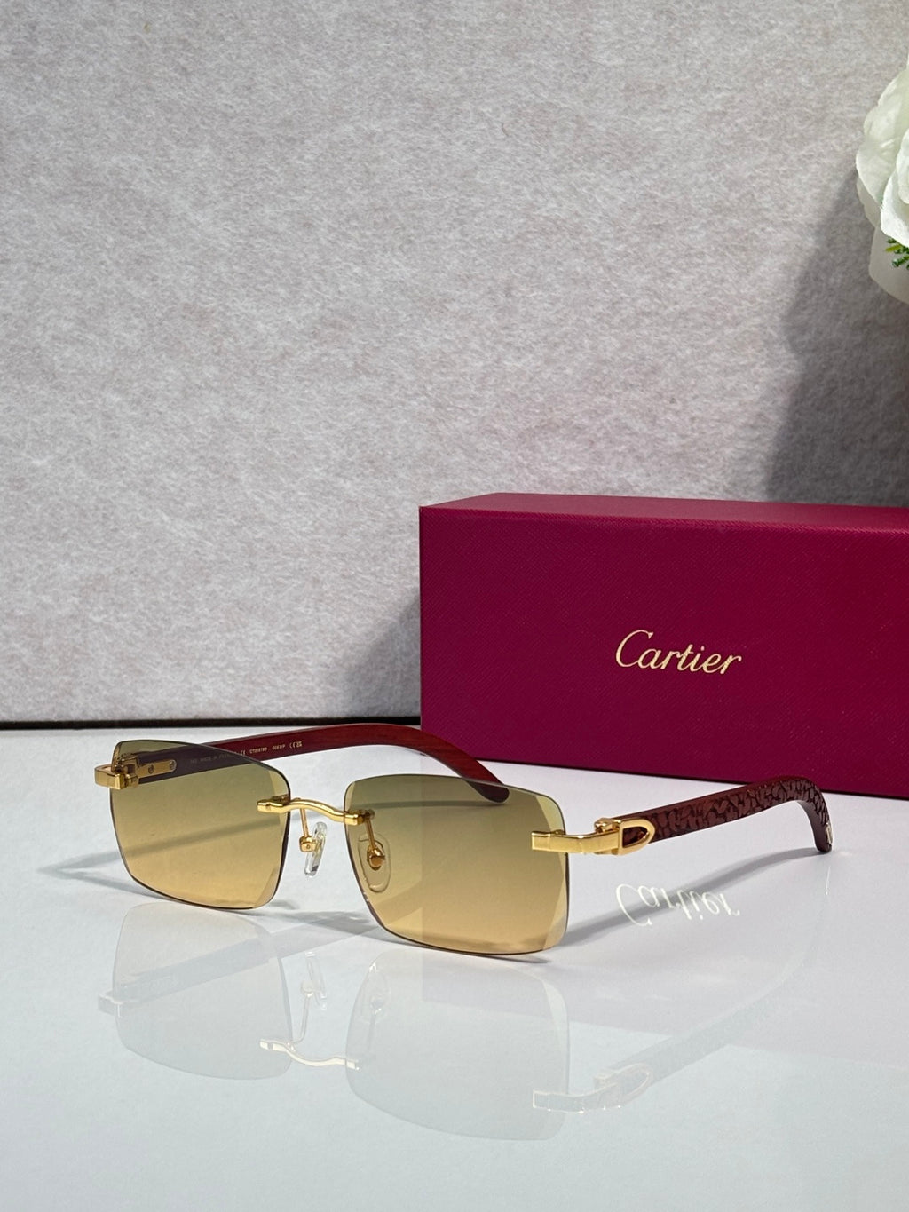 Cartier glasses, dark-brown frame with gold detailing and amber-tinted lenses