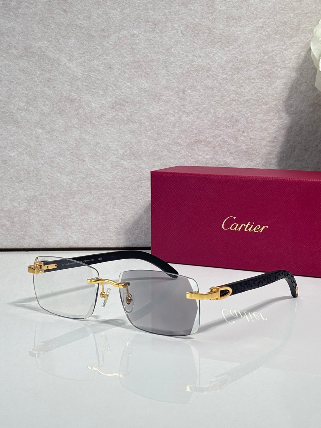 Cartier glasses, dark frame with gray-tinted lenses and gold detailing