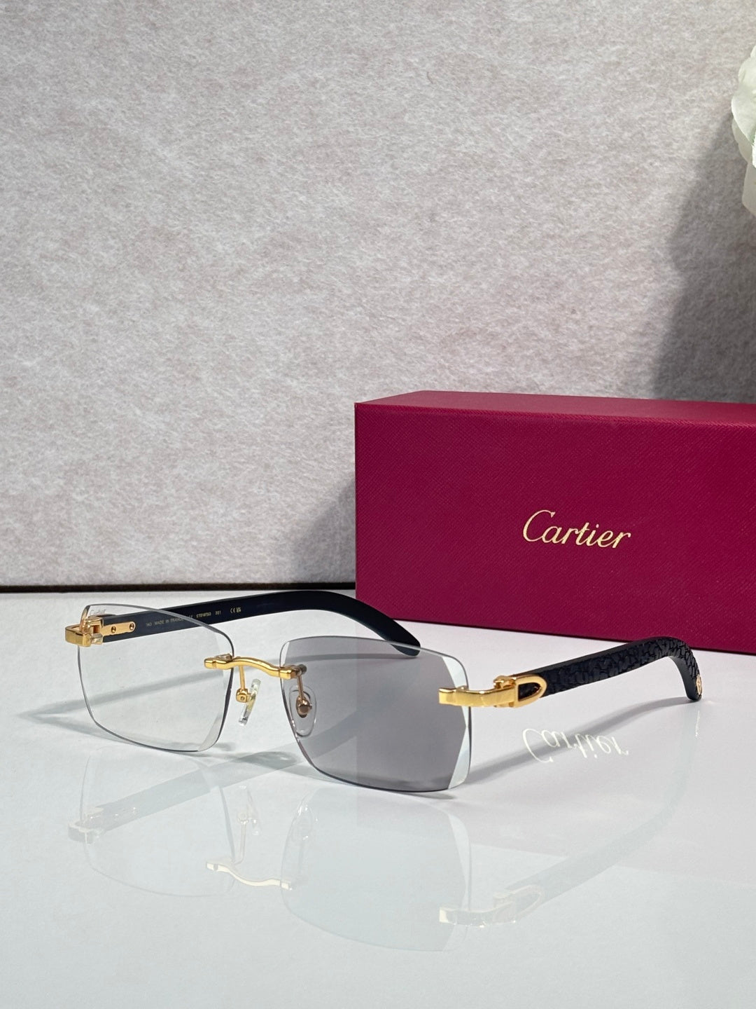 Cartier glasses, dark frame with gray-tinted lenses and gold detailing