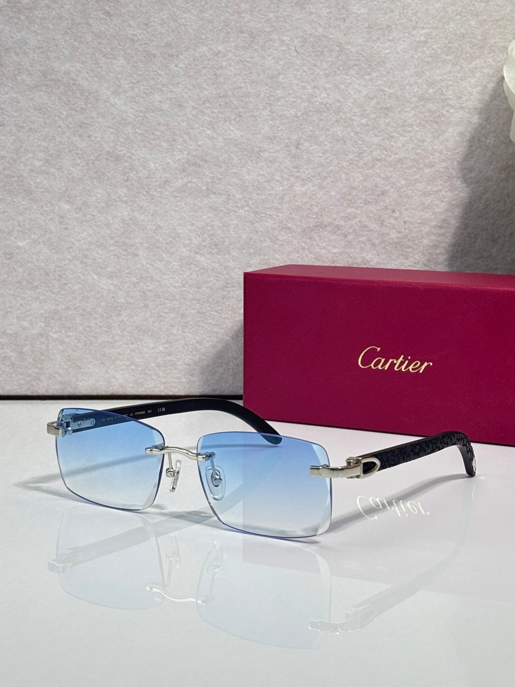 Cartier glasses, dark frame with blue-tinted lenses and gold detailing