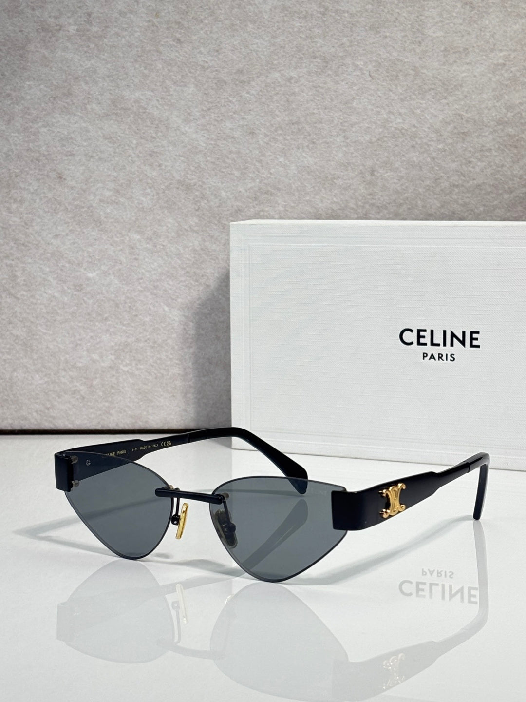 Celine glasses with gold frame, dark blue lenses, and black temple arms