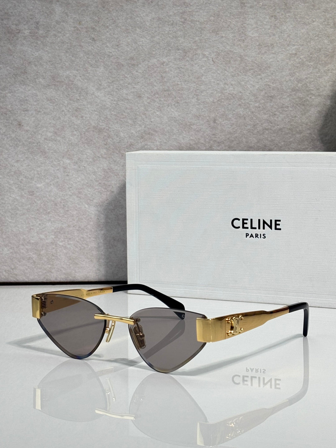 Celine glasses with gold frame, dark brown lenses, and black temple arms