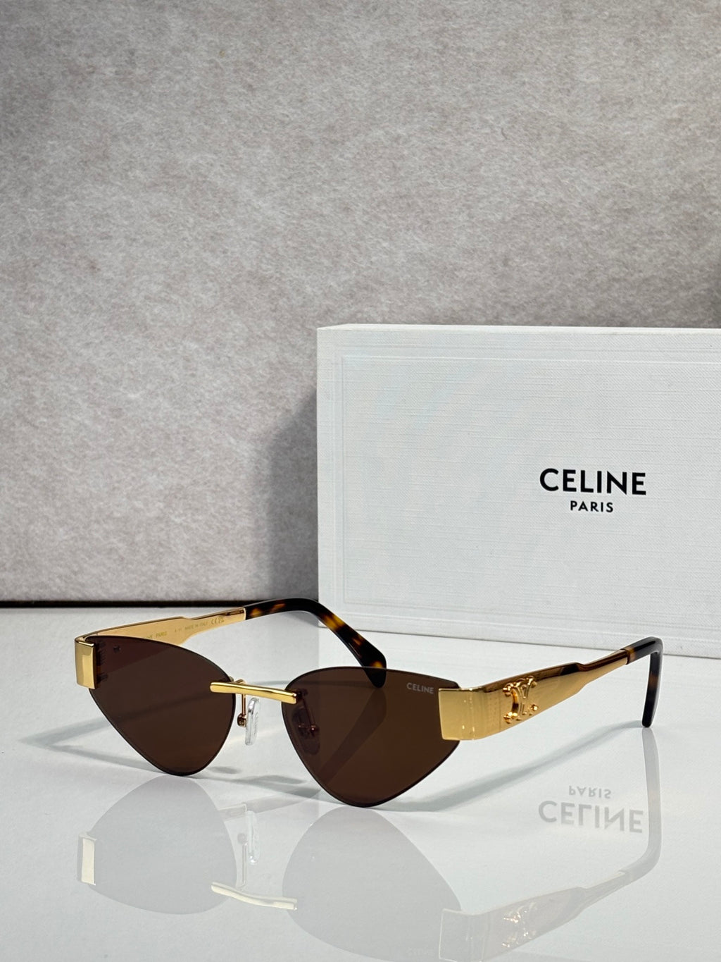 Celine glasses with gold frame, dark brown lenses, and tortoise top edges