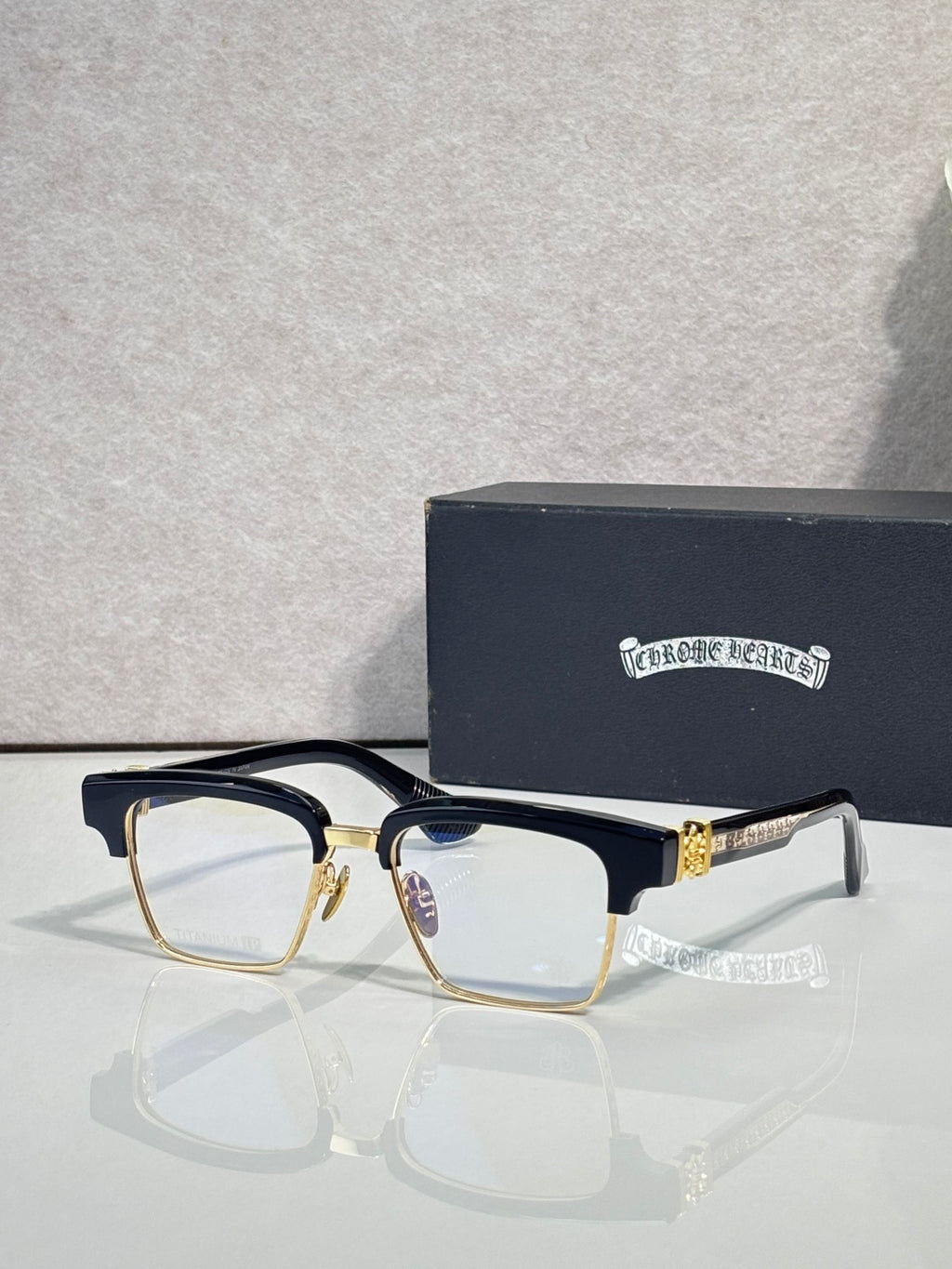 Gold-tone and dark eyeglass frames with square lenses and rhinestone temple details