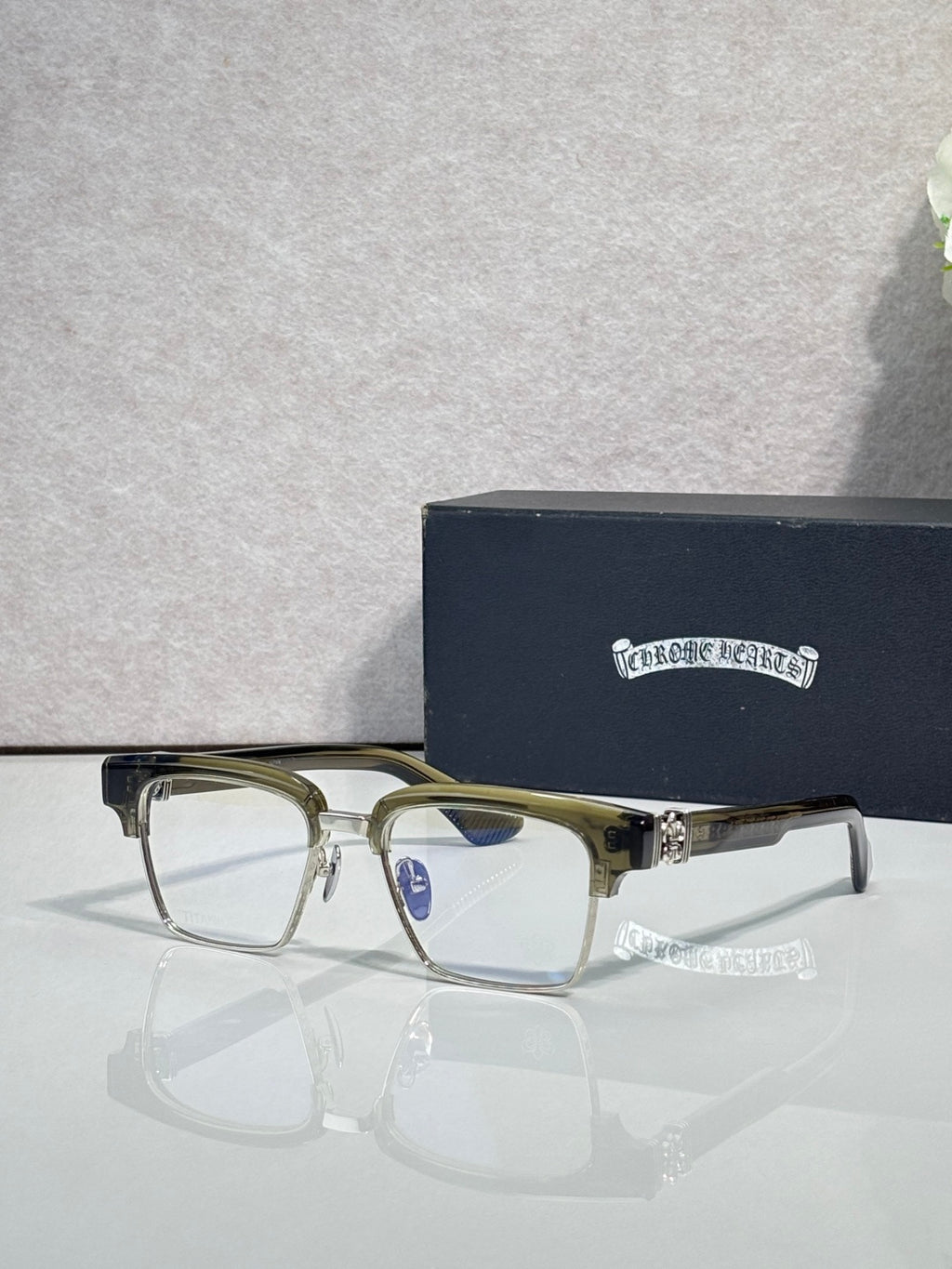 Gold-green and silver eyeglass frames with square clear lenses and rhinestone temple accents
