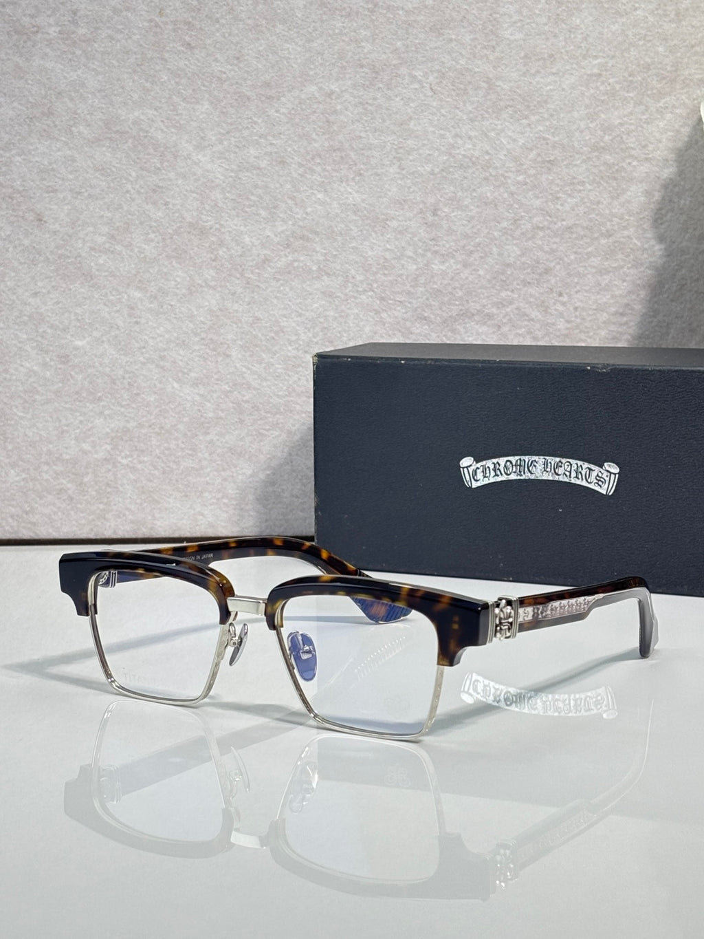 Eyeglass frames with square lenses, tortoise top rim, and gold-tone temple detail