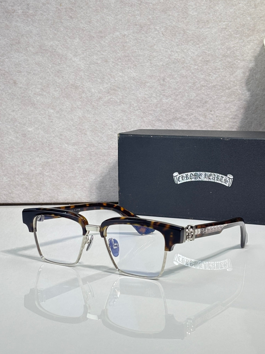 Eyeglass frames with square lenses, tortoise top rim, and gold-tone temple detail