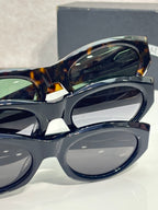 Close-up of cat-eye glasses frame with dark tortoiseshell top rim and tinted lens