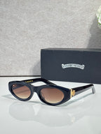Cat-eye glasses with black frame and brown-tinted lenses, with gold-toned side accents