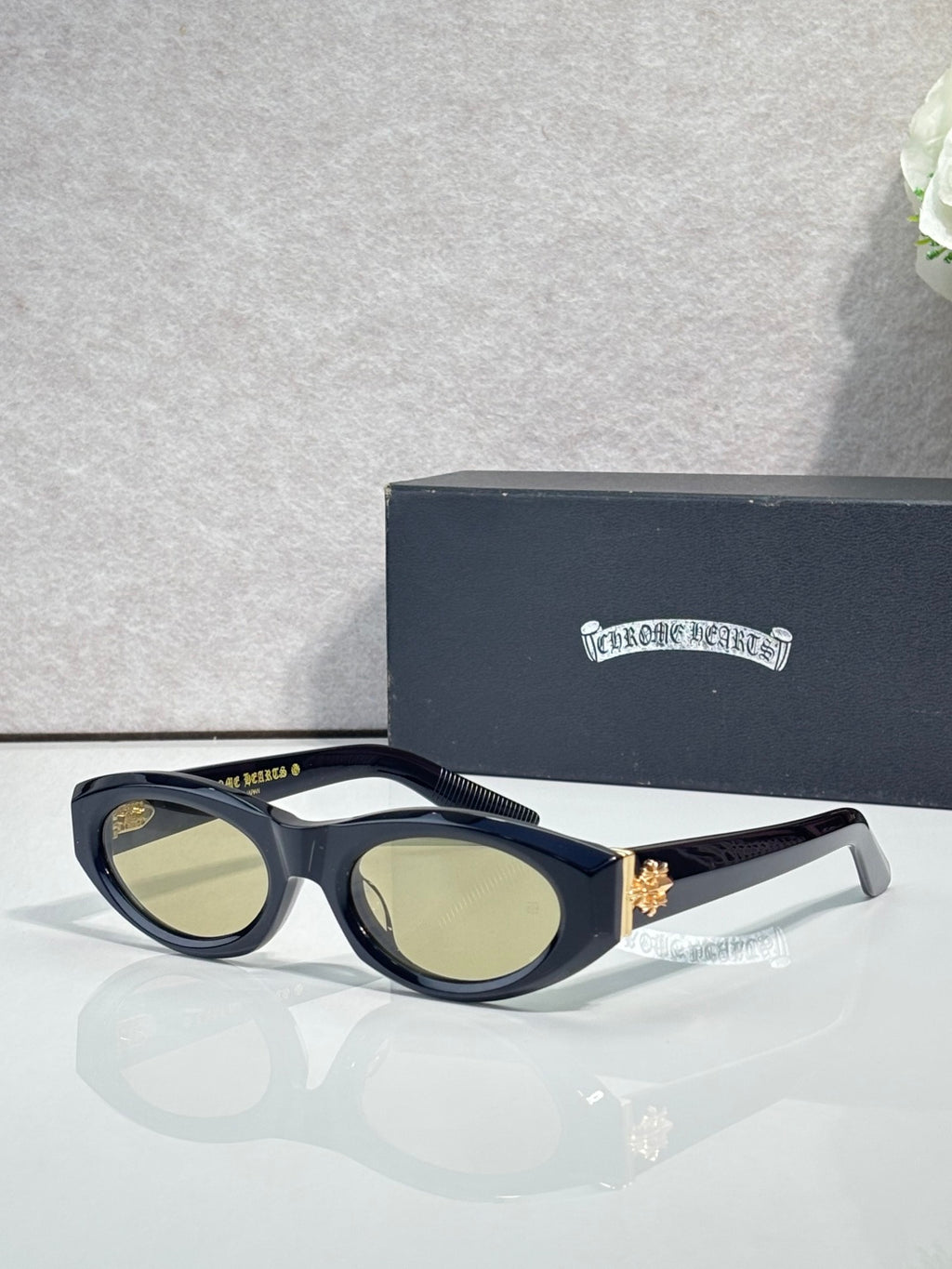 Cat-eye glasses with dark tortoiseshell pattern, light green tinted lenses, and metal trim