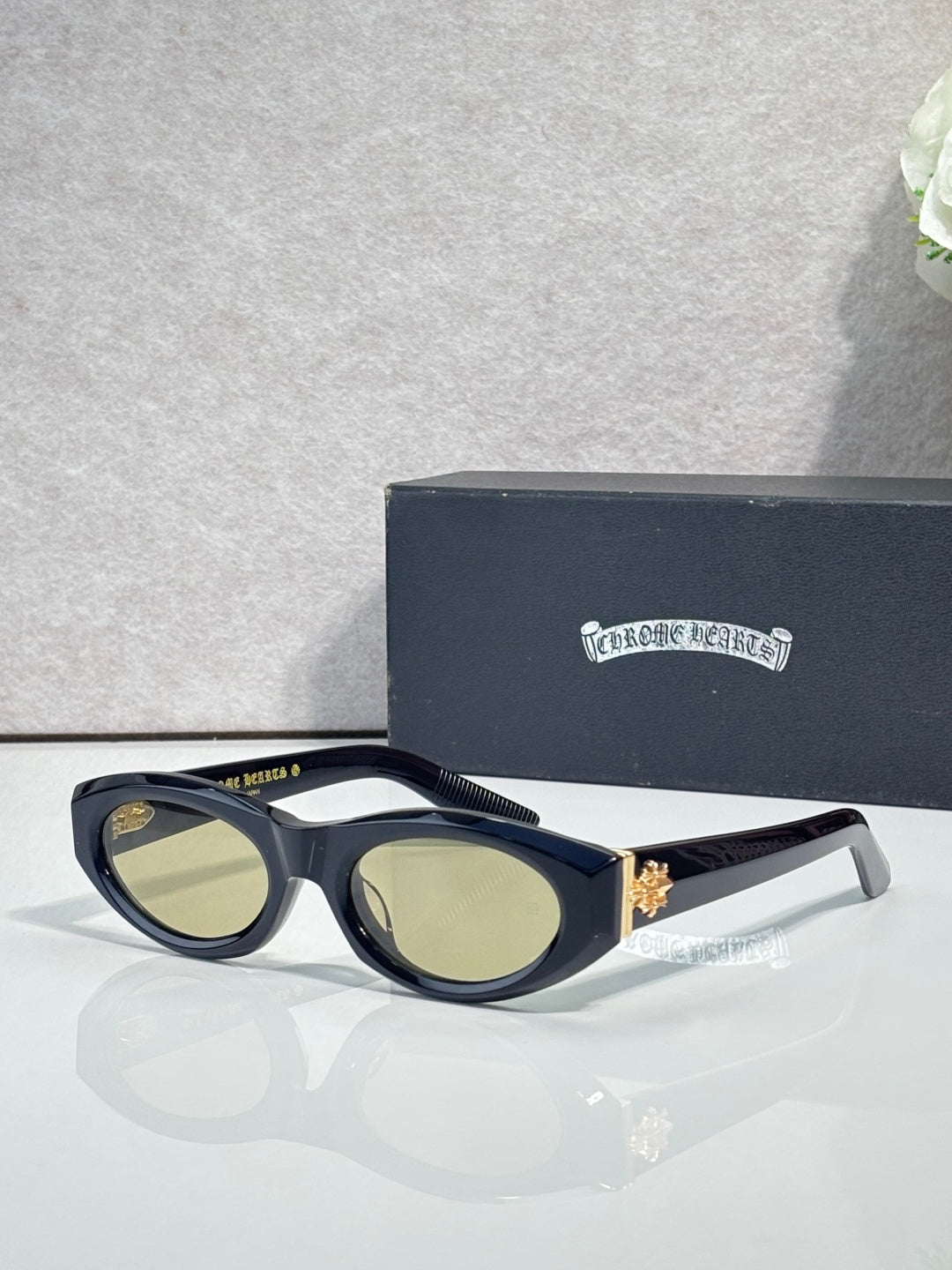 Cat-eye glasses with dark tortoiseshell pattern, light green tinted lenses, and metal trim