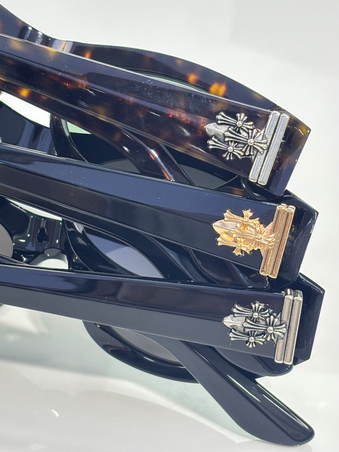 Close-up of temple hinge on dark cat-eye glasses with gold and silver decorative accents