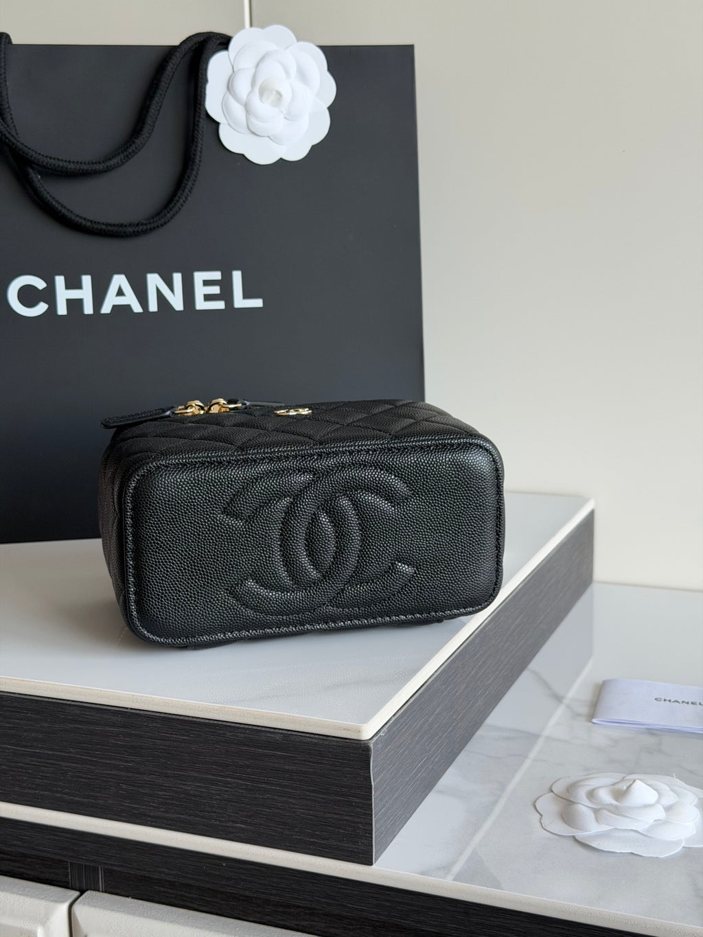 Quilted shoulder bag in black leather with embossed CC logo and gold hardware.
