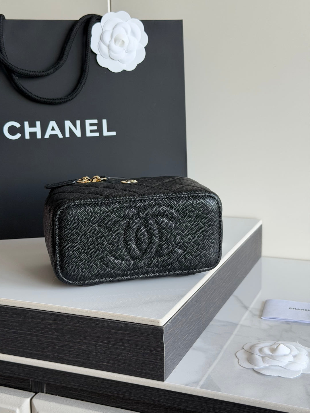 Quilted shoulder bag in black leather with embossed CC logo and gold hardware.