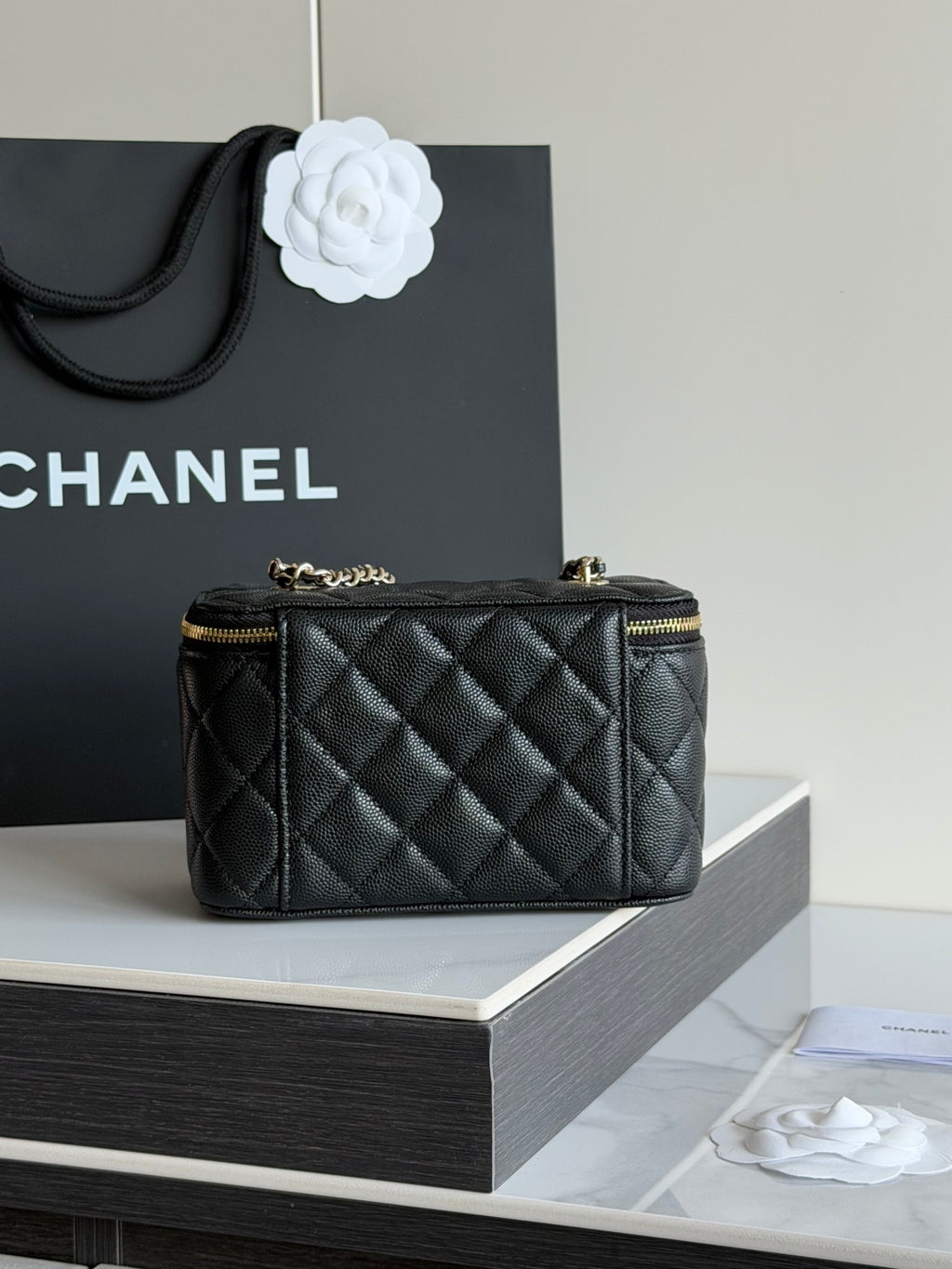 Quilted shoulder bag in black leather with top handle and gold hardware, CC emblem.