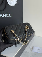 Quilted shoulder bag in black leather with gold zipper, chain strap, and CC emblem.