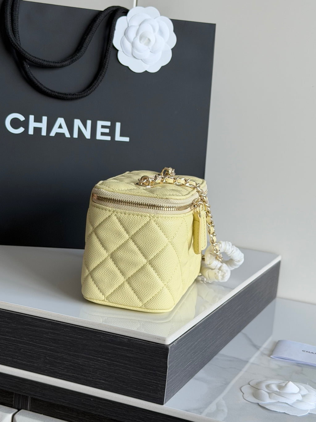 Chanel quilted mini crossbody bag in pale yellow with gold chain strap, back view