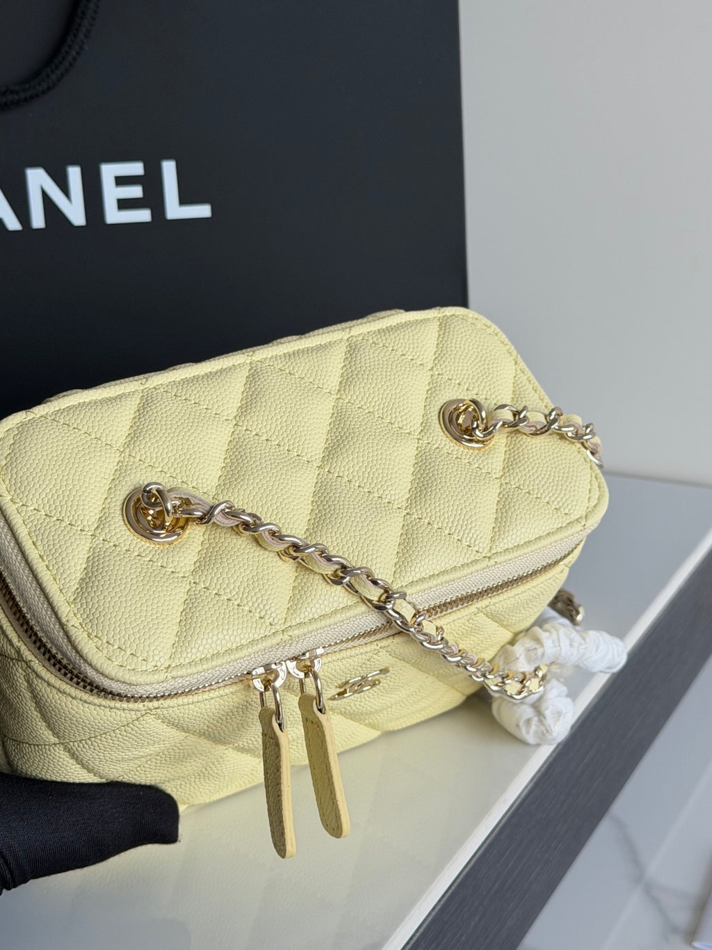 Chanel quilted mini bag in pale yellow with gold chain strap and zipper pull detail