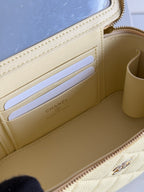 Chanel mini bag interior with card slot divider and gold-tone branding panel, pale yellow