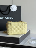 Chanel quilted mini crossbody bag with gold chain strap in pale yellow, side view on stand