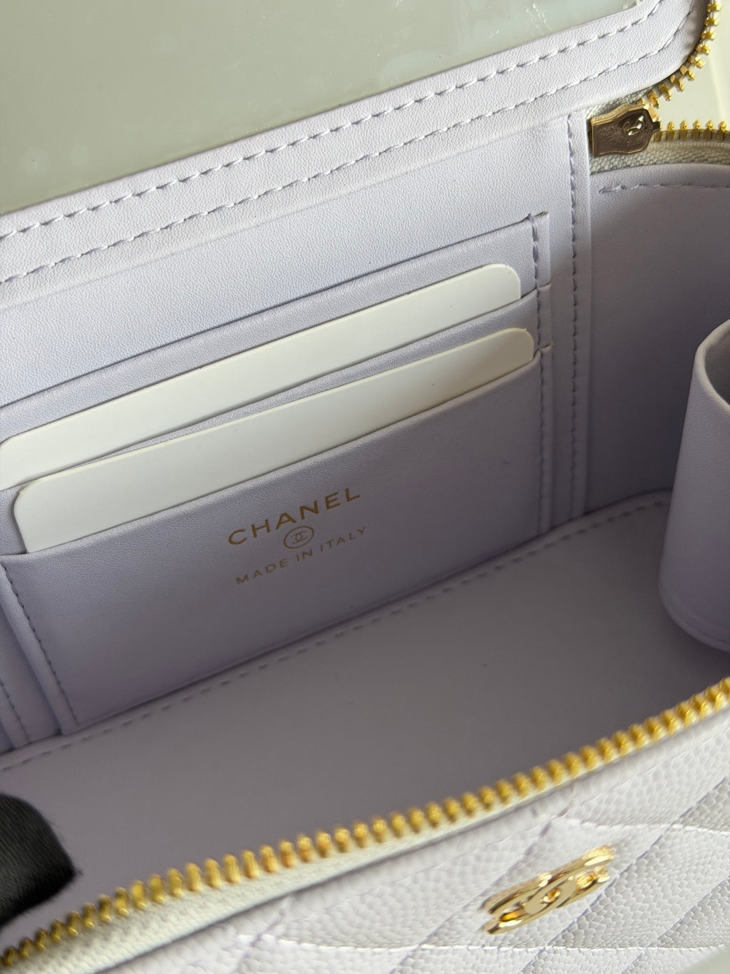Interior view of light lavender quilted bag with card slots and Chanel logo print