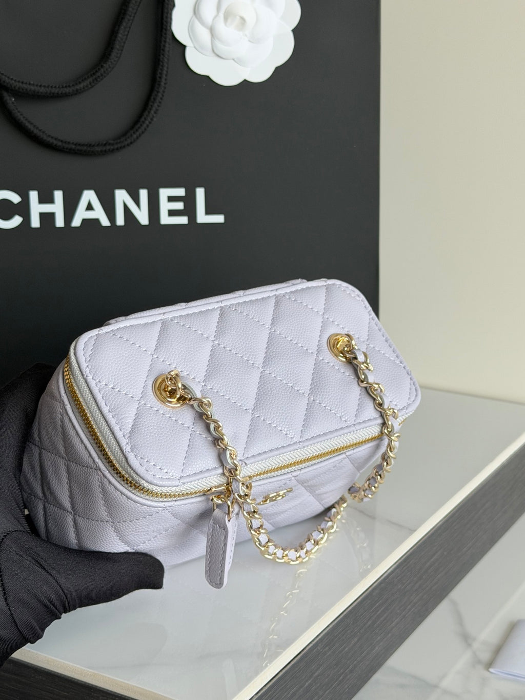 Light lavender quilted mini bag with gold chain straps and gold zipper detail