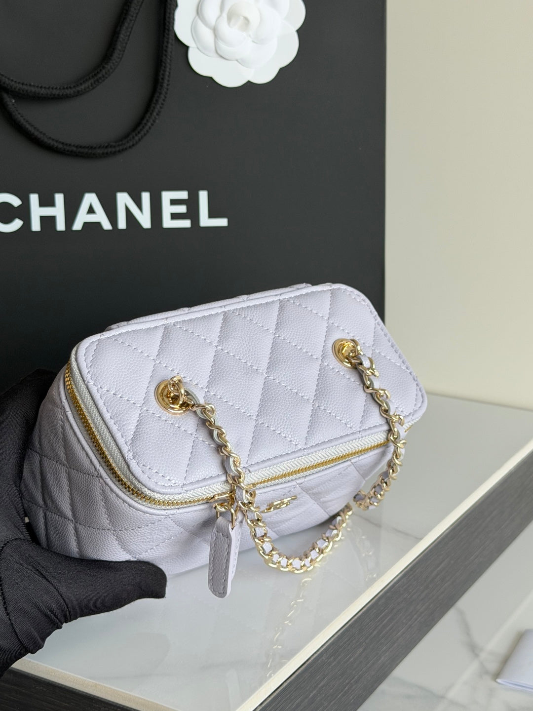 Light lavender quilted mini bag with gold chain straps and gold zipper detail