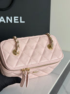Pale pink quilted mini flap bag with gold chain handles and front logo tab.