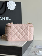 Quilted pale pink boxy mini bag with gold-tone hardware and top zip closure.