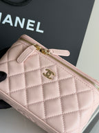 Close-up of pale pink quilted bag with gold zipper pull and CC logo hardware.