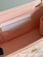 Interior of pale pink quilted mini bag with card slots and Chanel branding on lining.