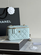 Chanel light blue quilted mini bag with gold zipper, top handles, and chain strap
