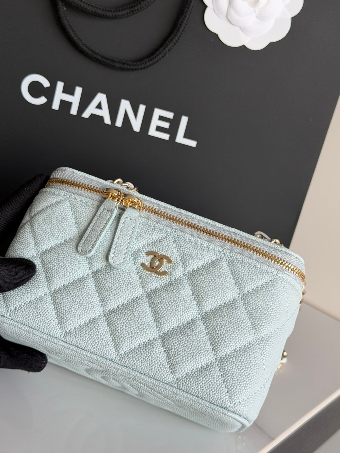 Chanel quilted light blue mini bag close-up of gold zipper and CC logo