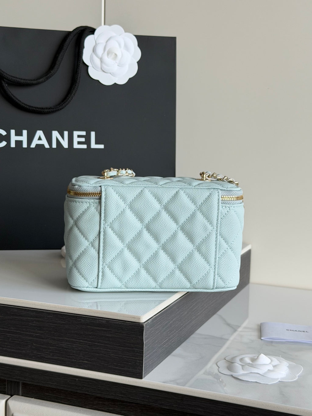 Chanel light blue quilted mini bag with gold trim and chain strap, front view