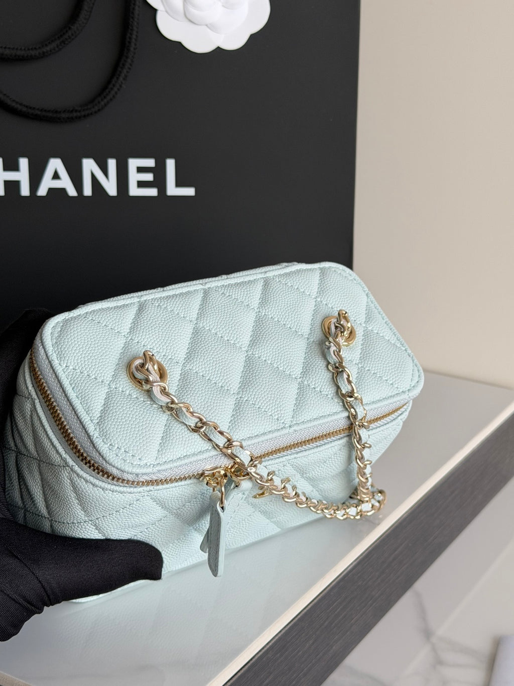Chanel light blue quilted mini bag close-up with gold chain strap and zipper pocket