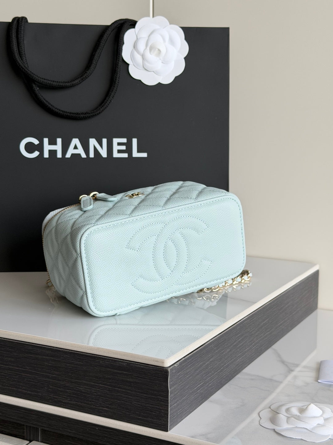 Chanel light blue mini bag with quilted texture, gold chain strap, and embossed CC