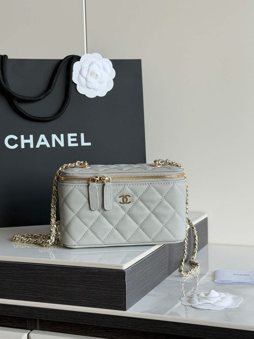 Small quilted Chanel handbag with double zip and gold chain strap.