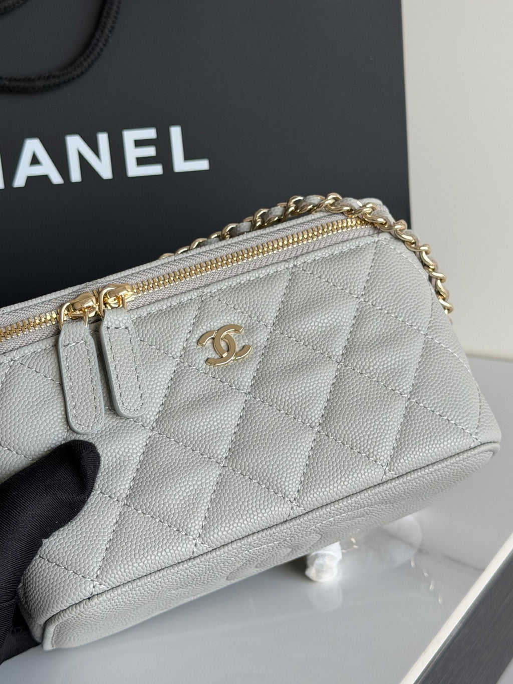 Quilted Chanel mini handbag with gold-tone zipper and CC logo on front.