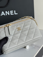 Quilted Chanel mini handbag with gold-tone zipper and CC logo on front.