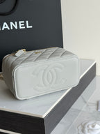 Quilted Chanel mini handbag with gold zipper and embossed CC on back.