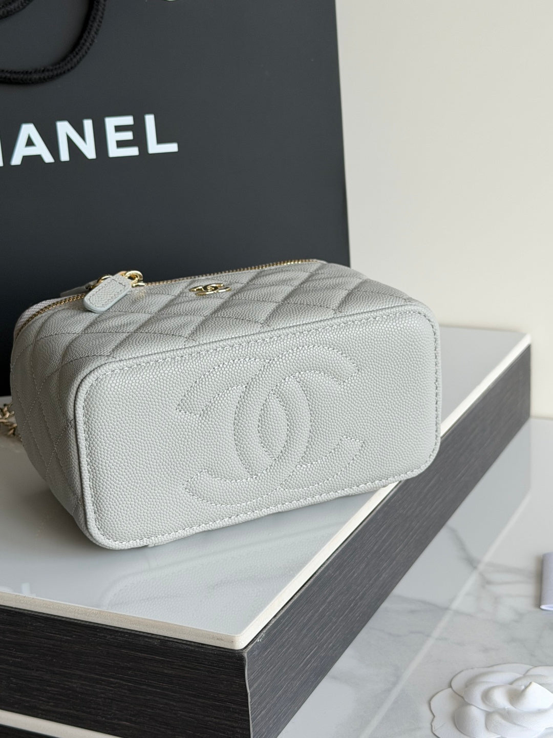 Quilted Chanel mini handbag with gold zipper and embossed CC on back.
