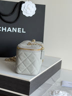 Mini quilted Chanel handbag with gold chain shoulder strap and top zip closure.